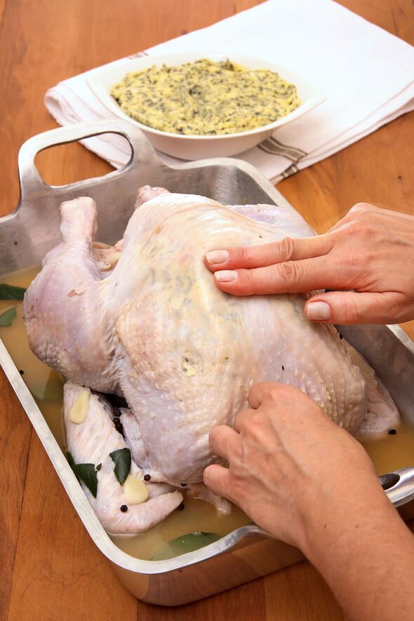 Woman rubbing butter on turkey to season