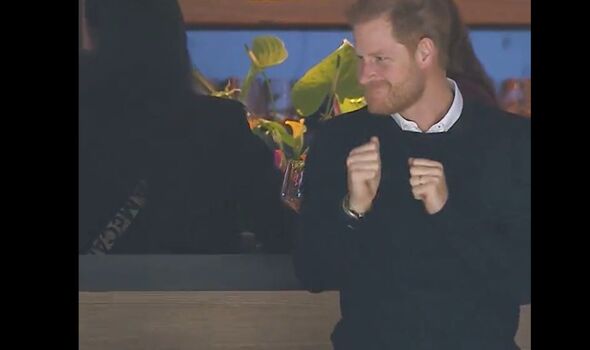 Prince Harry dances with fists clenched